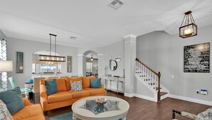 A living room with a sofa, coffee table, and a staircase.