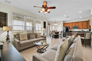 A modern living room with a sofa, coffee table, and dining area.