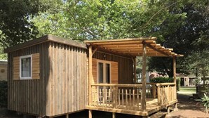 Une cabane en bois avec une véranda et une petite fenêtre.