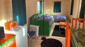 Une petite pièce agréable, dotée d’un lit simple, d’une chaise, d’une table et d’un radiateur.