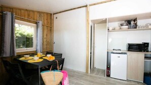 Een kleine keuken met een magnetron, fornuis en spoelbak.