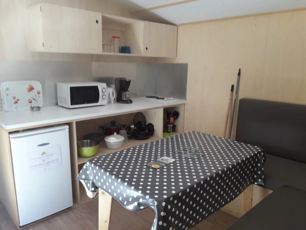 A compact kitchen with a microwave, coffee maker, and a small refrigerator.