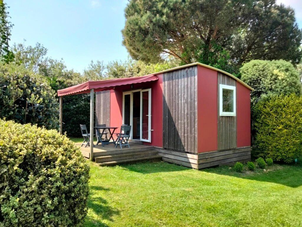 A small, single-story structure with a red exterior and a covered patio area.
