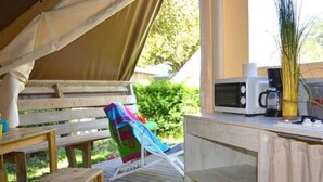 A covered outdoor area with wooden furniture, a microwave, and a coffee maker. - ZEcamping animé espace aquatique pet friendly locatif 17m2 4 pers (Le Château-d'Olonne)