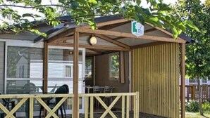 Une structure en bois dotée d’une terrasse, d’un patio couvert et d’une enseigne indiquant la présence d’un restaurant.