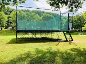 A large, open grassy area with a metal fence structure.
