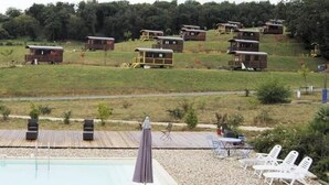 Et poolområde med liggestole og en træterrasse.