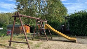 A playground with swings and a slide. - ZEcamping 2* dog friendly locatif 2 pers (Angicourt)