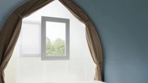 Une chambre à coucher avec un lit, une fenêtre avec des rideaux et une vue sur la verdure.