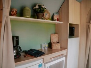 A kitchenette with a coffee maker, a kettle, and a small plant on a shelf. - ZEcamping 3 étoiles familial piscine chauffée mobil-home 16m2 (Florac)