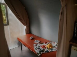 A single bed with a red mattress, a white pillow, and a floral-patterned blanket. - ZEcamping 3 étoiles familial piscine chauffée mobil-home 16m2 (Florac)