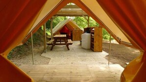 Une tente équipée d’une table de pique-nique et d’étagères de rangement.