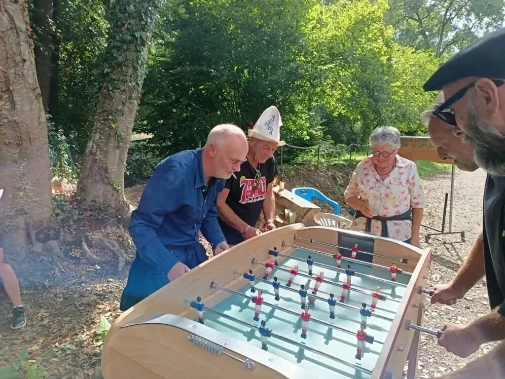 Un grupo de personas jugando al fútbol de mesa al aire libre.