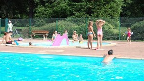 Piscina com pessoas ao redor.