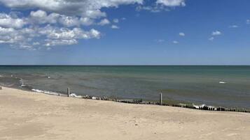 Ein Strand mit sandigem Ufer und blauem Himmel.