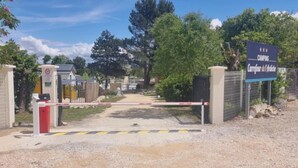 Una entrada cerrada a un área de camping con un cartel que indica 'Camping Carrefour de l'Isle'.