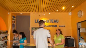 A reception area with a sign reading "LE CHATEAU CAMPING".