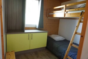 Ein Etagenbett mit Fenster, ein Schreibtisch mit Stuhl und eine Himmellaune.