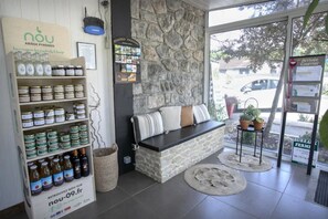 Um interior acolhedor com uma parede de pedra, uma área de estar com almofadas e uma exposição de potes e garrafas.