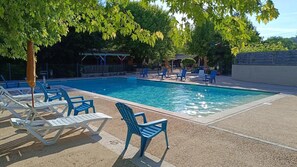 A swimming pool with lounge chairs and a covered seating area. - ZEcamping 3* piscine chauffée pataugeoire chiens acceptés locatif 17m2 (Antonne-et-Trigonant)