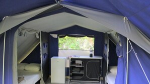 A tent with two beds, a small kitchenette, and a window. - ZEcamping 3* piscine pet friendly Tente tribu 4 pers (Belmont-sur-Rance)