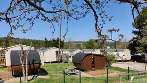 Un camping con cabañas portátiles, una zona de juegos cercada y cielo despejado.