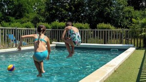 A swimming pool with a wooden deck and a grassy area. - ZEcamping piscine chauffée pet friendly locatif BBQ 4 pers (Chassenard)