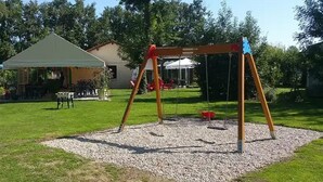 A playground with a swing set and a covered seating area. - ZEcamping 3 étoiles piscine couverte locatif BBQ 4 pers (Sandrans)
