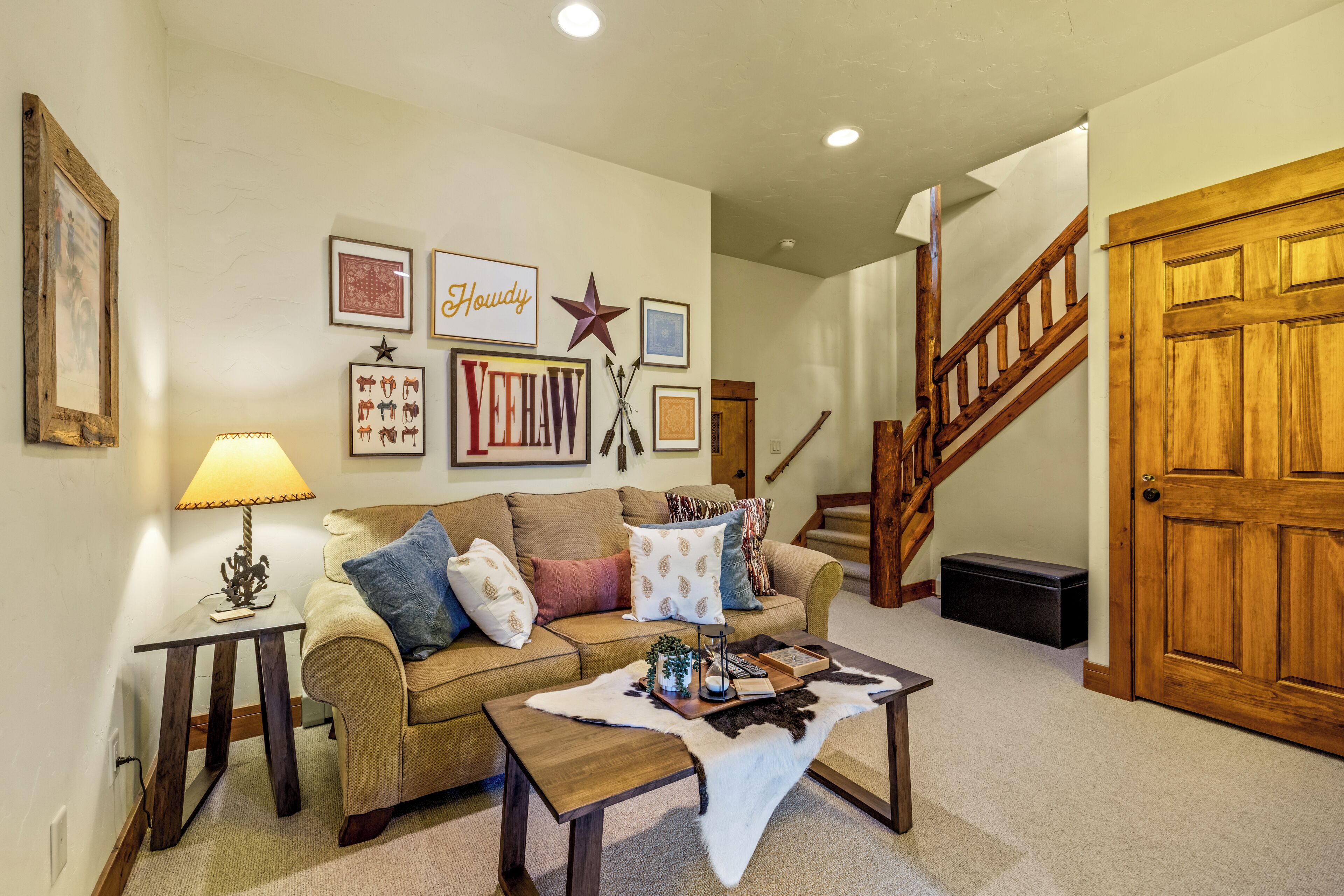 A living room with a sofa, coffee table, and wall decorations.