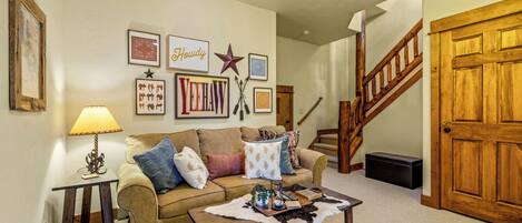A living room with a sofa, coffee table, and wall decorations.