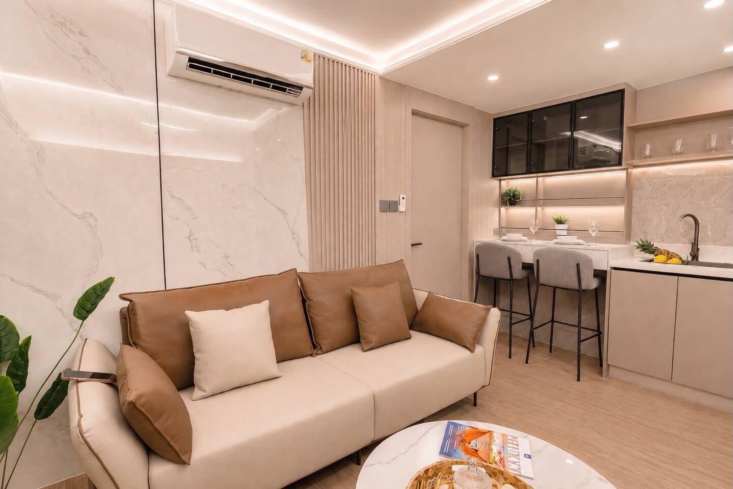 A modern living room with a sofa, a coffee table, and a kitchen area with a dining table.