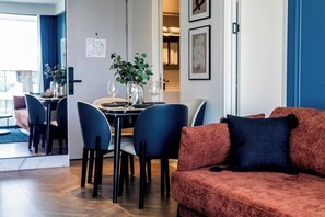 A modern interior with a dining area, a sofa, and a plant. - 2BR Beachside Resort - 50m to the sea (Choeng Thale)