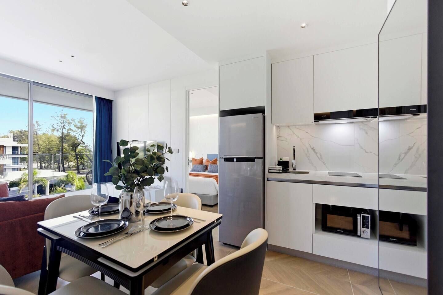 Frigorífico, placa de cocina, utensilios de cocina y mesa de comedor