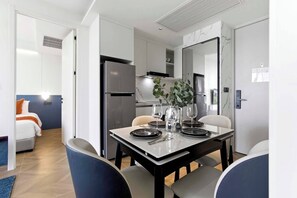 A modern hotel room with a dining area, a kitchen, and a separate bedroom. - 2BR Beachside Resort - 50m to the sea (Choeng Thale)