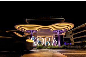 Ein modernes Gebäude mit leuchtendem Schild 'KORA' bei Nacht.