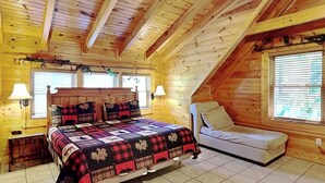 A bedroom with a bed, a chair, and a window. - Budget friendly, Smoky Mountain Cabin Rental | Sleeps 10 | Pool Table (Pigeon Forge)