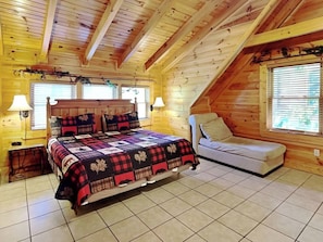 A bedroom with a bed, a chair, and a window. - Budget friendly, Smoky Mountain Cabin Rental | Sleeps 10 | Pool Table (Pigeon Forge)