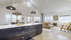 A spacious living area with a large island, pendant lighting, and a fireplace. - Charming French Country Farmhouse in lovely Santa Rosa
3 night minimum (Santa Rosa)