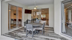 Ein modernes Interieur mit Essbereich, Deckenventilator und Fernseher.