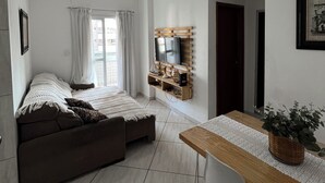 Ett modernt vardagsrum med en soffa, en tv och ett matbord.
