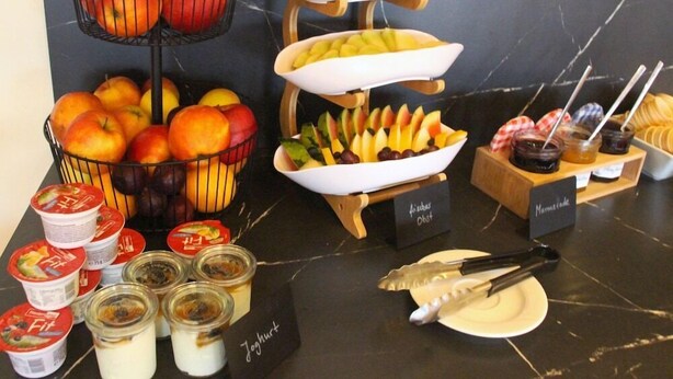 Un buffet amb diverses fruites, iogurt i complements.