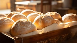 A basket of round, golden-brown bread rolls. - Comfort Hotel Leipzig West (Schkeuditz)