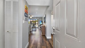 A hallway with a wooden floor, white doors, and a ceiling fan.