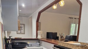 Una cocina compacta equipada con microondas, cafetera y un refrigerador pequeño.