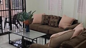 A living room with a sofa, coffee table, and a potted plant. - Una Casita Acogedora en Tenares (Tenares)