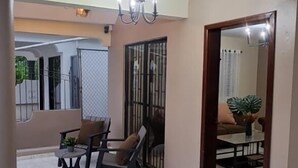 A room with a dining area, a chandelier, a mirror, and a view of the outside. - Una Casita Acogedora en Tenares (Tenares)