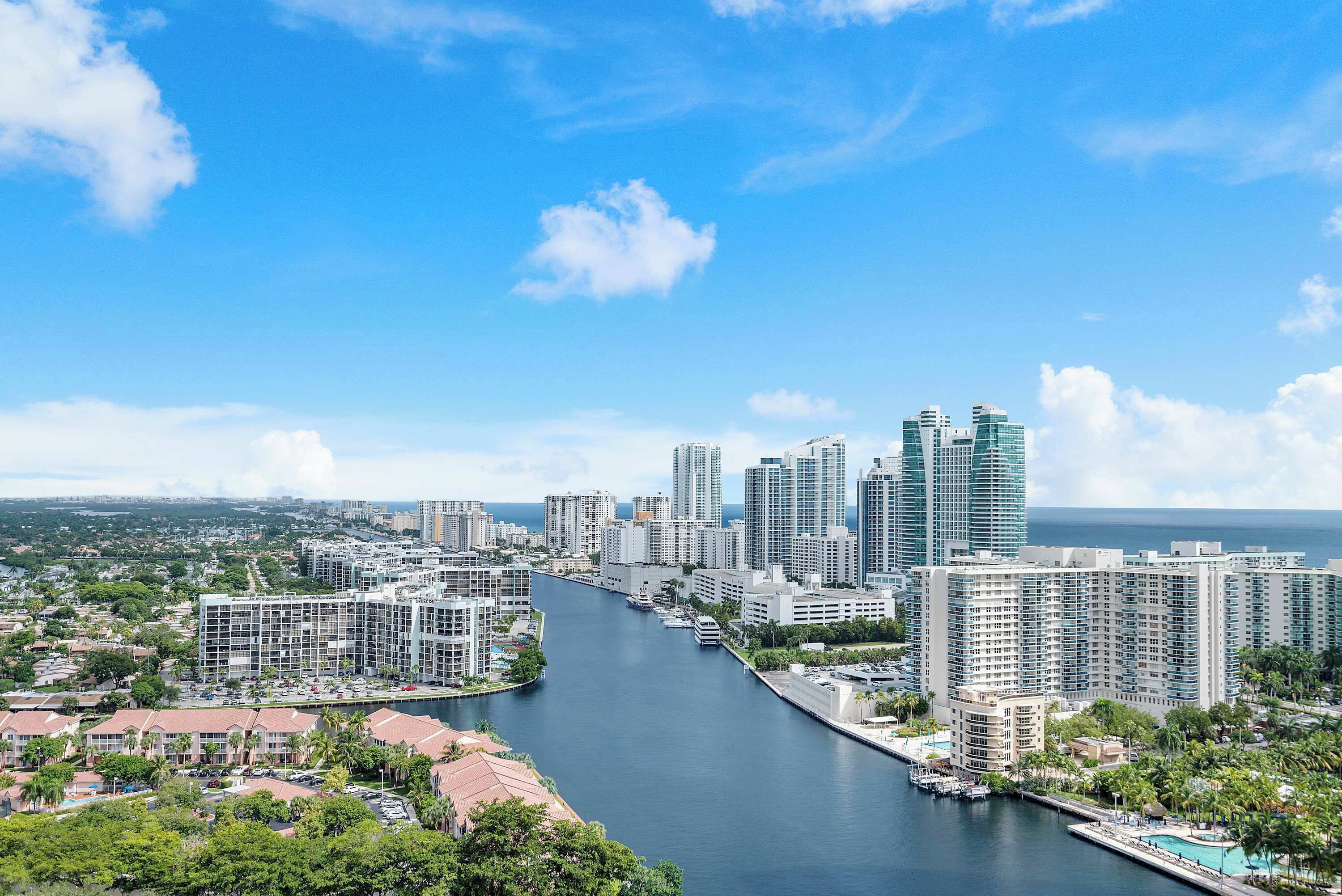 A cityscape with a river, high-rise buildings, and a clear sky.