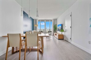 Een moderne woonruimte met een eethoek, keuken en grote ramen.