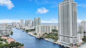 Un hotel di grandi dimensioni con piscina, situato vicino a una banchina con altri edifici.