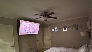 A bedroom with a bed, a ceiling fan, a TV on the wall, and a door. - Pleasant 2-bedroom apartment with AC in Beverly Hills Near Rodeo Dr. (Beverly Hills)